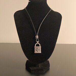 Stigma necklace with black cord and silver tone cross pendant